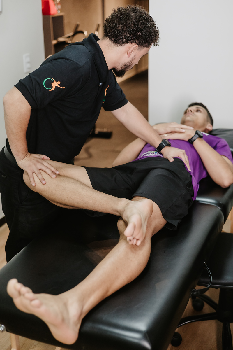 Fisioterapeuta mobilizando o quadril de um paciente